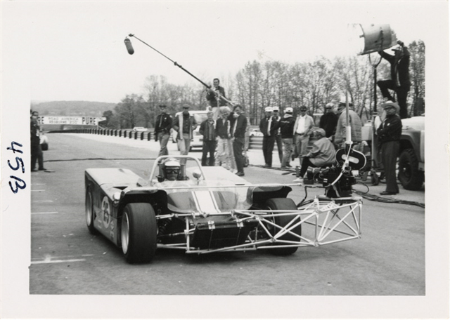 Paul Newman behind the wheel of the camera car A remote-controlled motion picture camera was mounted to the car frame to capture close-up driver shots. Invented by cameraman by Richard Moore and used for the first time at Road America, the camera could be operated either trackside or by a passenger in a trailing car.