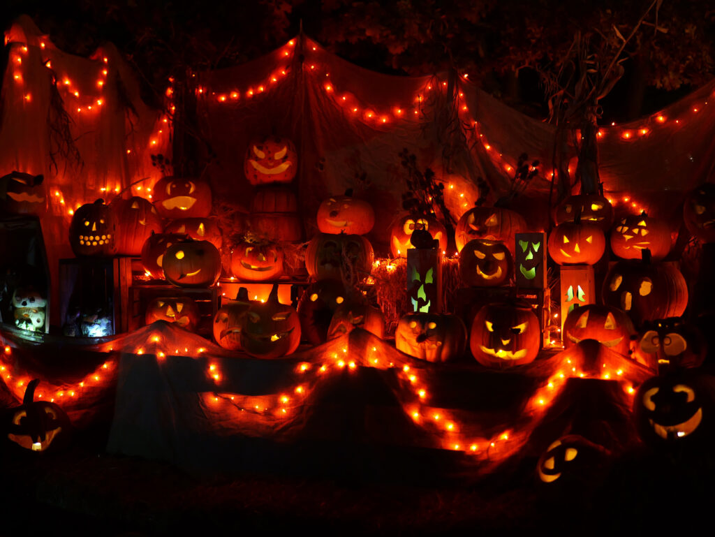 Display of jack-o-lanterns with orange lights and other Halloween decorations
