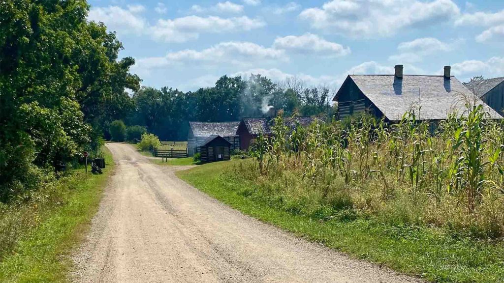 Buildings at Old World Wisconsin surrounded by lush trees and crops