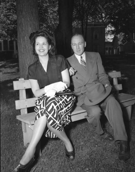 Louis Dousman, great grandson of Hercules Louis Dousman who built the home, is seated on a bench on the lawn with his wife.